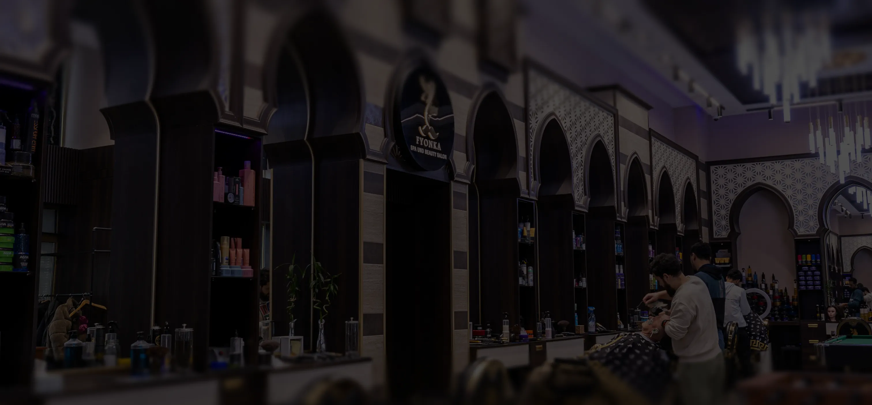 Wellnessbereich mit brennenden Teelichtern, Wasserkrug mit Gläsern und Schale mit Handtüchern auf einem Marmortisch.