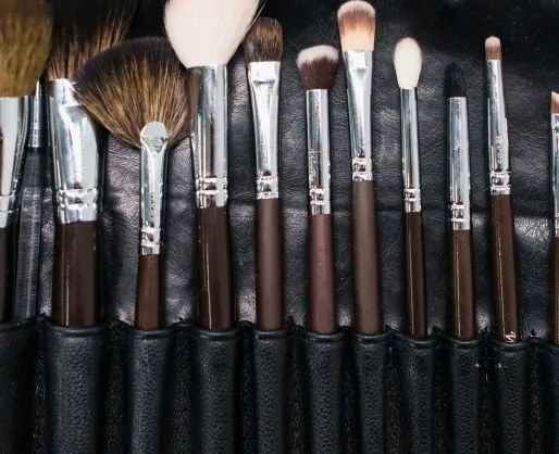 Verschiedene Makeup-Pinsel in einer schwarzen Halterung arrangiert.