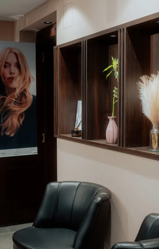 Friseur schneidet einem Mann mit dunklem Haar und Bart im Salon die Haare.