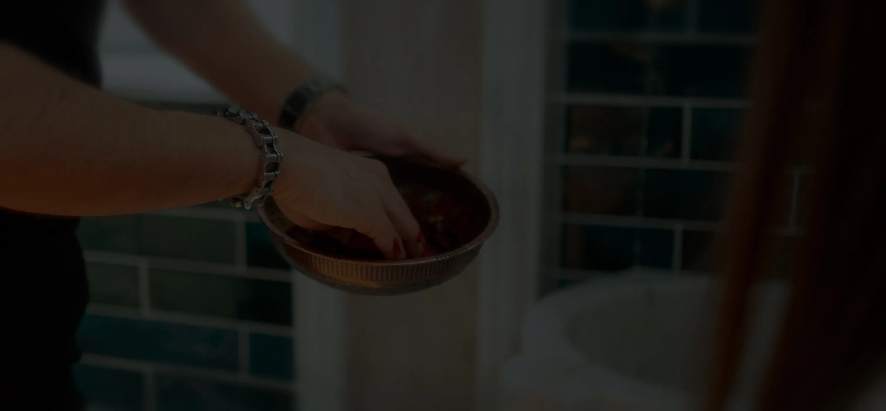 Wellnessbereich mit brennenden Teelichtern, Wasserkrug mit Gläsern und Schale mit Handtüchern auf einem Marmortisch.